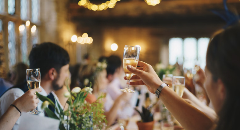 Mehrere Personen auf einer Business-Party in Berlin stoßen in der Luft an.