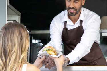 Das Bild zeigt die Essensausgabe an einer Food-Station beim Eventcatering in Berlin.