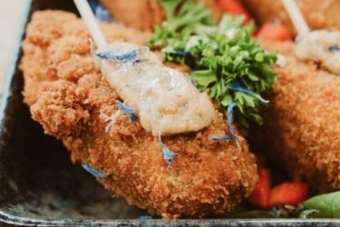 Das Foto zeigt knusprige Hühnchenteile für ein Eventcatering-Buffet.