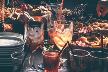 Verschiedene Cocktails und Snackkörbe als Teil eines Partyservice-Angebots.